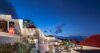 Evening view of hillside St Barts villa with red rooftops and illuminated terraces