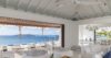 Elegant open living room in St Barts villa with ocean-view terrace and shaded lounge chairs