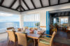 Open-air dining area in St Barts villa with sea views and rattan chairs