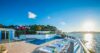 Seafront pool terrace at St Barts villa with sun loungers and sunset ocean views