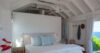 Bright bedroom in St Barts villa with vaulted ceiling and ocean view terrace