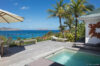Plunge pool with wooden deck, palm trees, and sweeping ocean views in a luxury St Barts villa rental.