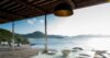 Covered outdoor dining area with modern tableware overlooking the Caribbean Sea and green hills in St Barts.