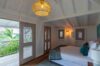 pacious bedroom featuring large windows that showcase a stunning view of lush greenery
