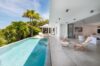 Relaxing poolside sunbathing spot furnished with cozy loungers and framed by serene surrounding