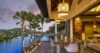 Relaxing infinity pool area shaded by graceful palm trees, blending nature and luxury.