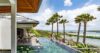 Serene infinity pool edged with lush palm trees against a clear blue sky