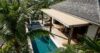 Beautiful infinity pool with green hues, overlooking expansive natural scenery.