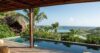 Beautiful infinity pool with green hues, overlooking expansive natural scenery.