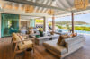 Lounge area inside a beautiful modern villa, featuring stylish furniture and large windows with stunning views of the surrounding landscape