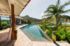 Relaxing poolside sunbathing spot furnished with cozy loungers overlooking a tranquil landscape.