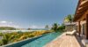 Sunbathing area beside a sparkling pool, featuring comfortable loungers and sunny skies