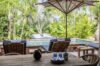 Shaded terrace in a St Barts villa with dining table, plunge pool, and sun loungers surrounded by lush tropical greenery.