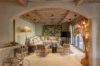 Rustic-chic living room in a St Barts villa with wood-beamed ceiling, colourful artwork, and cozy seating area.
