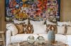 Art-filled living room in a St Barts villa with patterned cushions, rustic décor and colorful wall painting