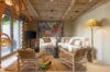 Rustic living room with woven furniture, artwork, and wooden ceiling at luxury villa in St Barts