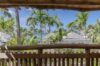Balcony view of palm trees and rooftops with glimpse of sea at St Barts villa rental