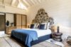 Elegant villa bedroom in St Barts with patterned headboard, soft lighting, and natural wood accents.