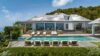 Luxury St Barts villa with expansive pool, sun loungers, and hillside backdrop.