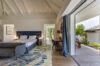 Elegant villa bedroom in St Barts with terrace access, modern decor, and natural light