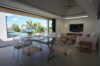 Open-concept living and dining area with glass table and poolside view at a luxury villa in St Barts