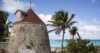 Rustic stone windmill villa in St Barts with shaded terrace and views over the Caribbean Sea.