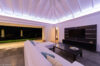 Modern living room with white sofas, ambient ceiling lighting, and open terrace views at night in a St Barts villa rental.