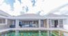 Modern villa exterior with stone accents and private pool reflecting the sky in a luxury St Barts villa rental.