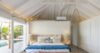 Airy bedroom in a St Barts villa rental with vaulted ceiling, poolside view, and coastal décor.