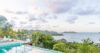 Infinity pool at a St Barts villa overlooking lush tropical hills and the Caribbean Sea at sunset.