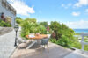 Spacious St Barts villa bedroom with king bed, soft lighting, and terrace doors opening to ocean views.