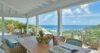 Bright St Barts villa bedroom with ocean-view balcony, crisp linens, and airy island style.