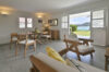 Open-plan living and dining room with wooden table, modern kitchen, and staircase inside a St Barts villa rental.