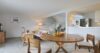 Bright open-plan living and dining area with wooden furniture and fruit centerpiece in a St Barts villa rental.