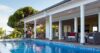 Private pool beside a shaded terrace with rattan seating and lush greenery at a luxury St Barts villa rental.