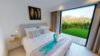 Cozy bedroom with neutral tones, garden views through sliding doors, and elegant decor in a St Barts villa rental.