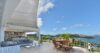 Spacious St Barts villa kitchen with sleek design, central island, and views of the terrace.