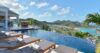 Elegant St Barts villa bedroom with soft lighting, ocean view terrace, and serene ambiance.