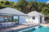 Poolside deck with sun loungers and outdoor dining area beside a contemporary St Barts villa rental.
