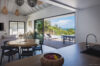 Open-plan kitchen and dining area flowing to a terrace with pool and ocean views in a St Barts villa rental.