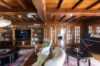 Warm villa living room with wooden beams, bookshelves, and piano in St Barts.