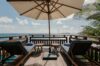 Oceanfront deck with sun loungers and umbrella overlooking the Caribbean at a private villa in St Barts.