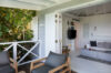 Covered terrace with lounge chairs opening into a bright living room at a St Barts villa rental.