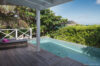 Shaded terrace with plunge pool at a St Barts vacation rental overlooking lush greenery and sea.