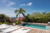 Sun loungers beside a private pool with tropical greenery and ocean view at a St Barts villa rental.