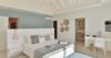 Bright villa bedroom with soft neutral décor, vaulted ceiling, and ensuite bathroom in St Barts.