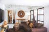 Stylish living area with brown sectional sofa, decorative accents, and natural light in a St Barts villa.