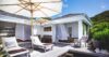 Sun loungers under umbrellas on a breezy terrace with flowing curtains at a private villa in St Barth
