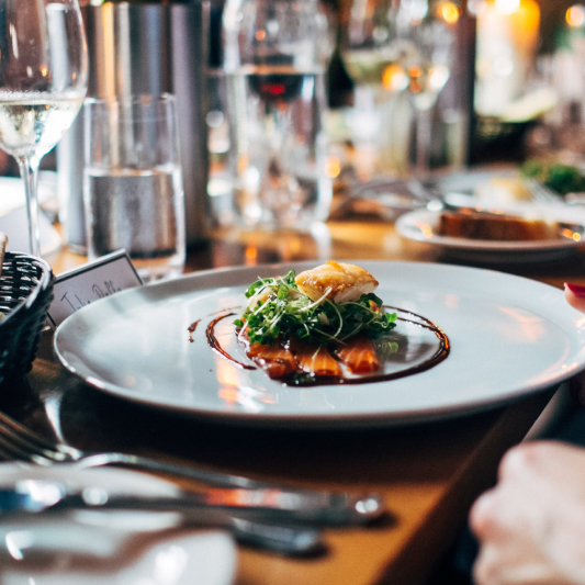 Fine dining plate featuring artfully arranged sliced salmon and seared scallop with microgreens and balsamic drizzle at St. Barts luxury villa.