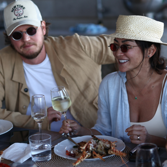 St. Barts villa birthday dining: couple enjoying lobster dinner with wine at casual-chic outdoor table setting